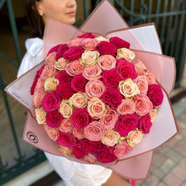 Large bouquet of pink and cream roses wrapped in pink paper