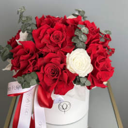 Bouquet of red and white roses with eucalyptus in a white hat box