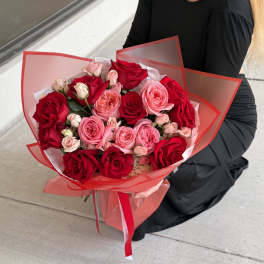 Bouquet of red and pink roses wrapped in red translucent paper