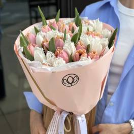Bouquet of pink and white tulips wrapped in pale pink paper