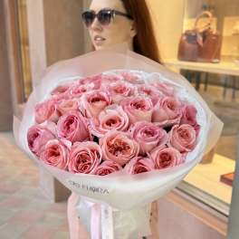 Large bouquet of pink roses wrapped in white paper with a ribbon