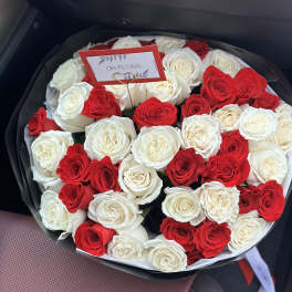 Round bouquet of red and white roses in black wrapping