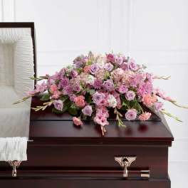 Pink and lavender floral spray on a dark casket