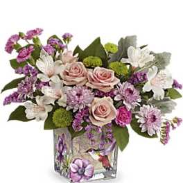 Pink and white floral arrangement in a decorated glass vase