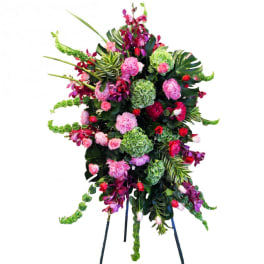 Tall standing floral spray with pink, red, and green blooms