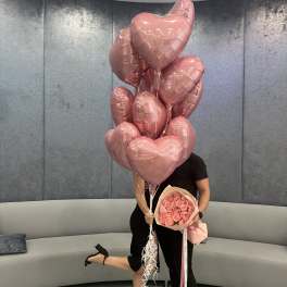 Pink heart balloons with a bouquet of pink roses