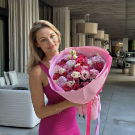 Woman holding a large pink bouquet of roses and lisianthus