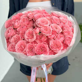 Large bouquet of pink peonies wrapped in translucent paper