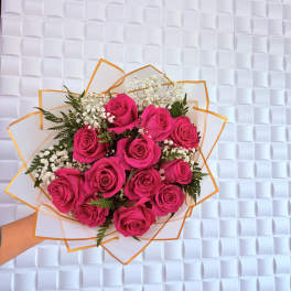 Handheld bouquet of hot pink roses with white baby's breath