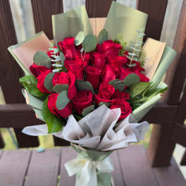 Bouquet of red roses wrapped in pale green and white paper