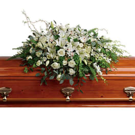 White floral spray on a wooden casket