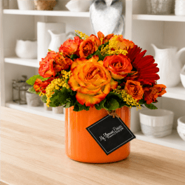 Orange and red rose bouquet in an orange vase