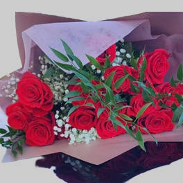 Bouquet of red roses with baby's breath and greenery in pink and burgundy wrap