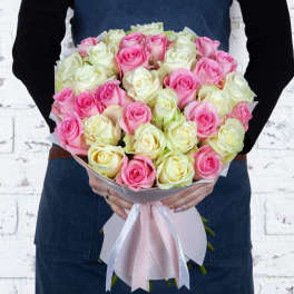 Bouquet of pink and white roses wrapped with a pink ribbon