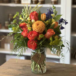 Colorful mixed bouquet in a clear glass jar vase