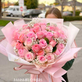Large bouquet of pink roses wrapped in pale pink paper