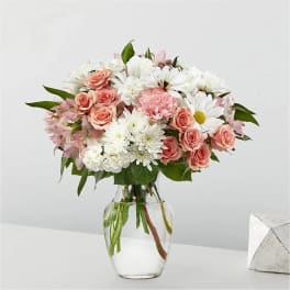 Pink roses and white daisies in a clear glass vase