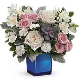Pink and white roses in a blue glass vase with white blooms