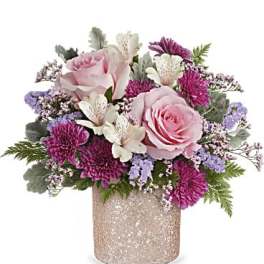 Pink roses and purple blooms arranged in a glittery vase