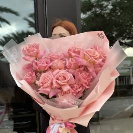 Large bouquet of pink roses wrapped in pale pink paper