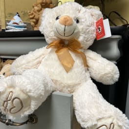 White teddy bear with a gold ribbon bow