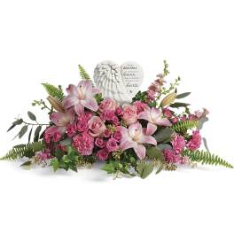 Pink lilies and roses arranged around a memorial angel plaque