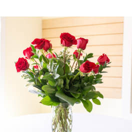 Red roses arranged in a clear glass vase