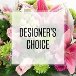 Pink and white mixed flowers behind a "Designer’s Choice" sign