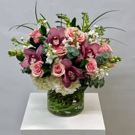Pink roses and purple orchids in a glass vase