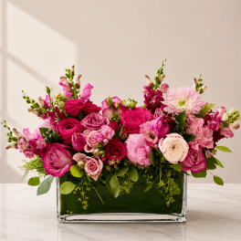 Pink floral arrangement in a rectangular glass vase