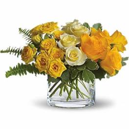 Yellow and white roses arranged in a clear glass vase