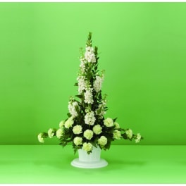 Tall white floral arrangement in a white pedestal vase