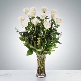 Tall bouquet of white roses in a clear glass vase