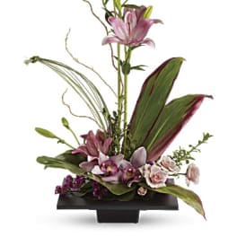 Tall floral arrangement with pink lilies and orchids in a black vase