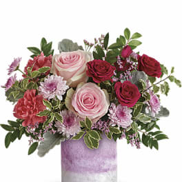 Pink and red rose bouquet in a lavender vase