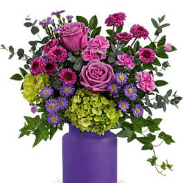 Pink and purple flowers arranged in a purple vase