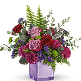 Bouquet of pink and red flowers in a purple square vase