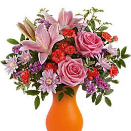 Pink lilies and roses in an orange vase