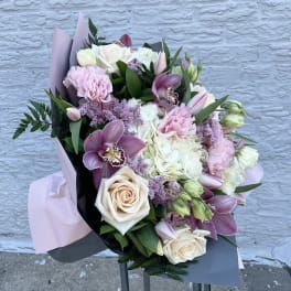 Bouquet of pink and white flowers wrapped in pastel paper