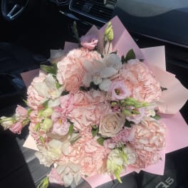 Pink and white bouquet with roses and lisianthus wrapped in pastel paper