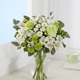 Green and white bouquet in a clear glass vase