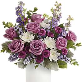Pink roses and purple flowers arranged in a white vase