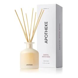 Cream glass reed diffuser with wooden sticks beside tall white Apotheke box