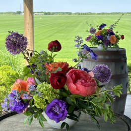 Colorful mixed flower arrangement in a white bowl on a round table