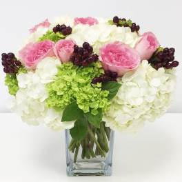Pink roses and white hydrangeas in a clear glass vase
