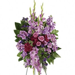 Standing floral spray with purple and pink flowers on a wire easel