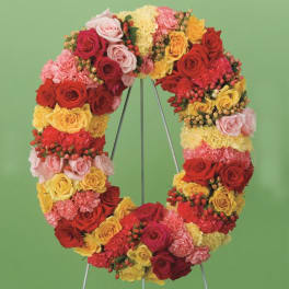 Heart-shaped floral wreath of roses and carnations on a stand