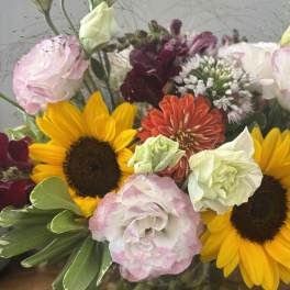 Mixed bouquet with sunflowers, pink and white blooms, and burgundy flowers