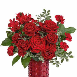 Red roses and carnations in a red heart-patterned vase