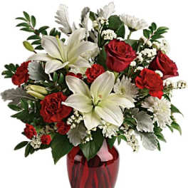 Red roses and white lilies in a red glass vase